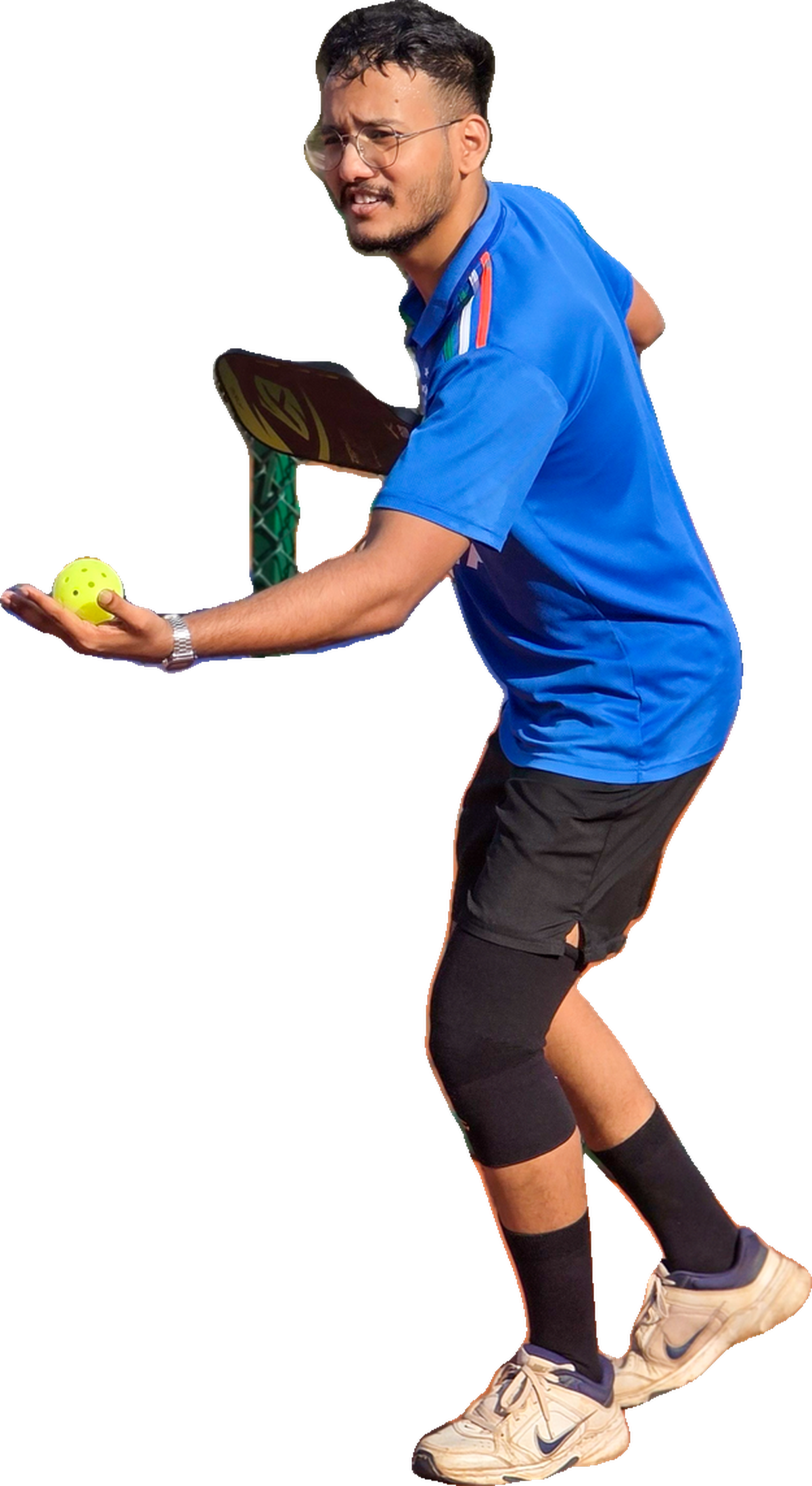 Milind Gauns mid-serve on a pickleball court